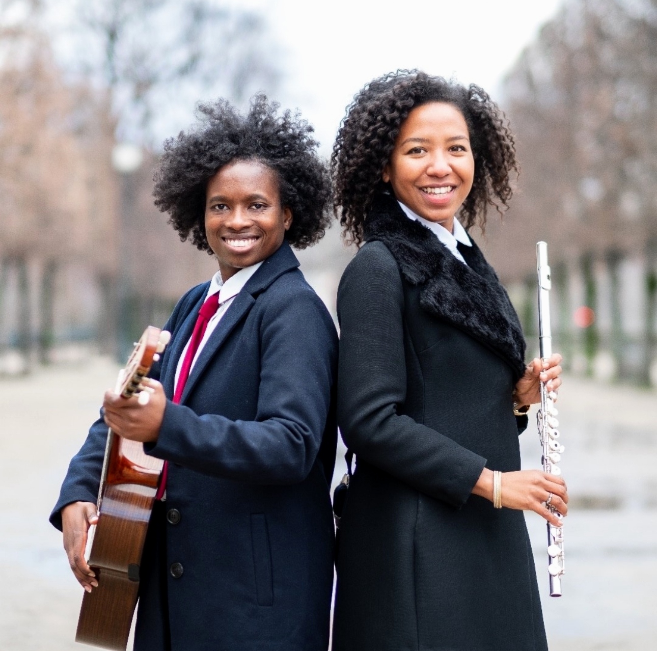 Flutist and guitarist standing together outdoors