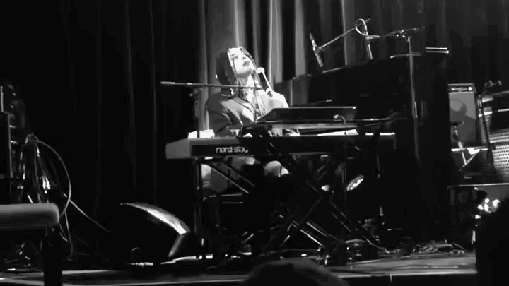 Film still of the vocalist performing at the piano